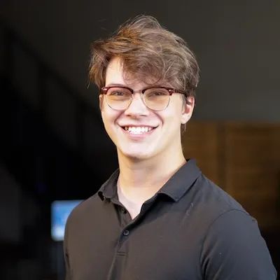 Young man smiling in a church community setting, symbolizing joy and fellowship in faith activities.
