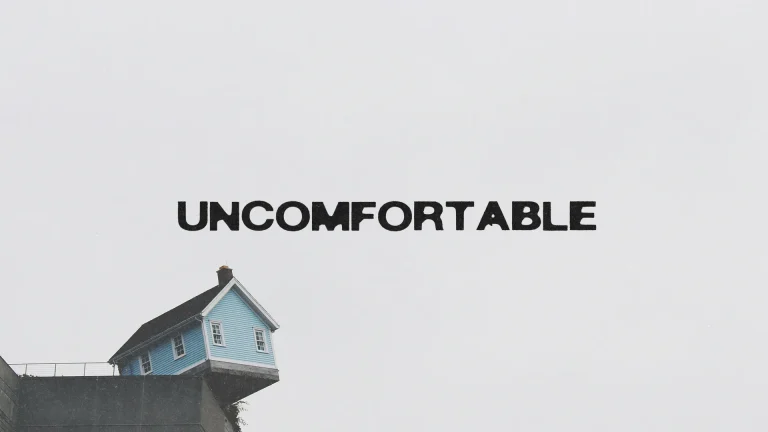 A blue house precariously balanced, symbolizing faith in uncomfortable situations and the strength of community.