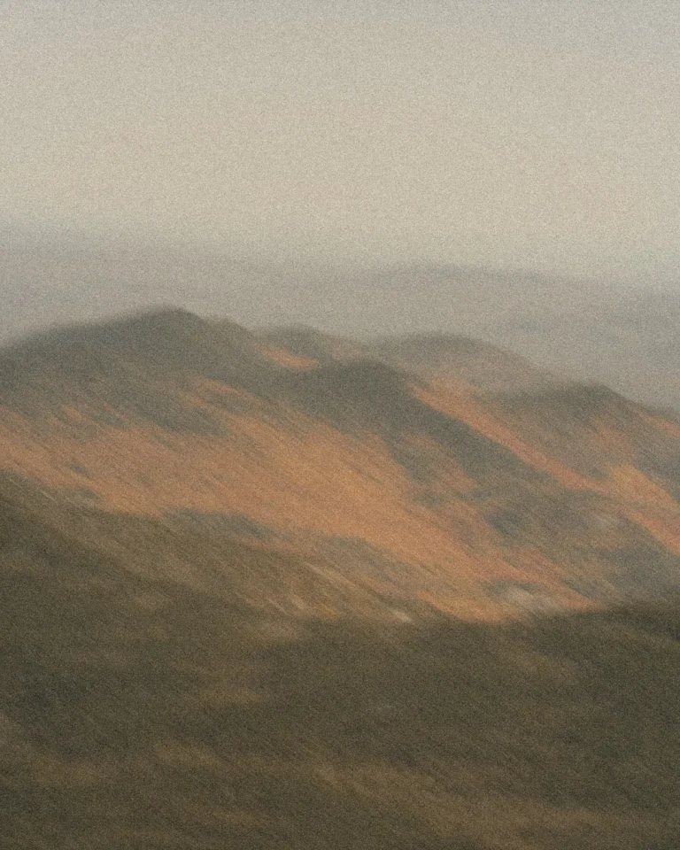 Soft, blurred mountains under a gentle sky evoke a sense of peace and reflection, inviting spiritual contemplation.