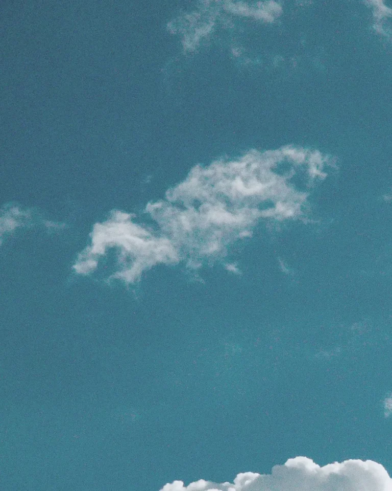 Bright blue sky with soft, white clouds, symbolizing hope and divine presence in worship and community.