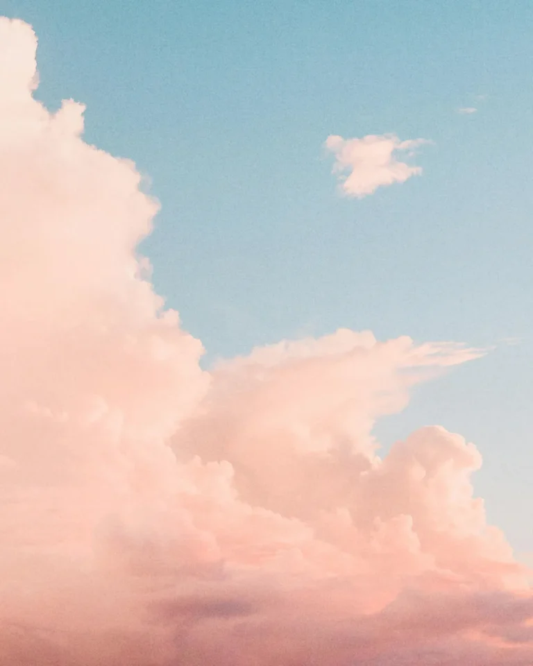 Soft pink clouds against a serene blue sky, evoking peace and divine presence in worship and reflection.