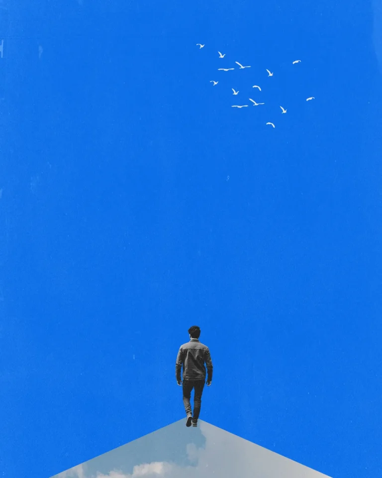 A figure stands on a peak, gazing upward as birds soar in a clear blue sky, symbolizing hope and spiritual journey.