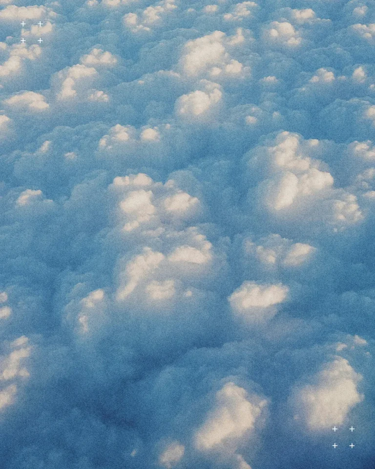 Fluffy white clouds against a serene blue sky, symbolizing peace, hope, and divine presence in worship.