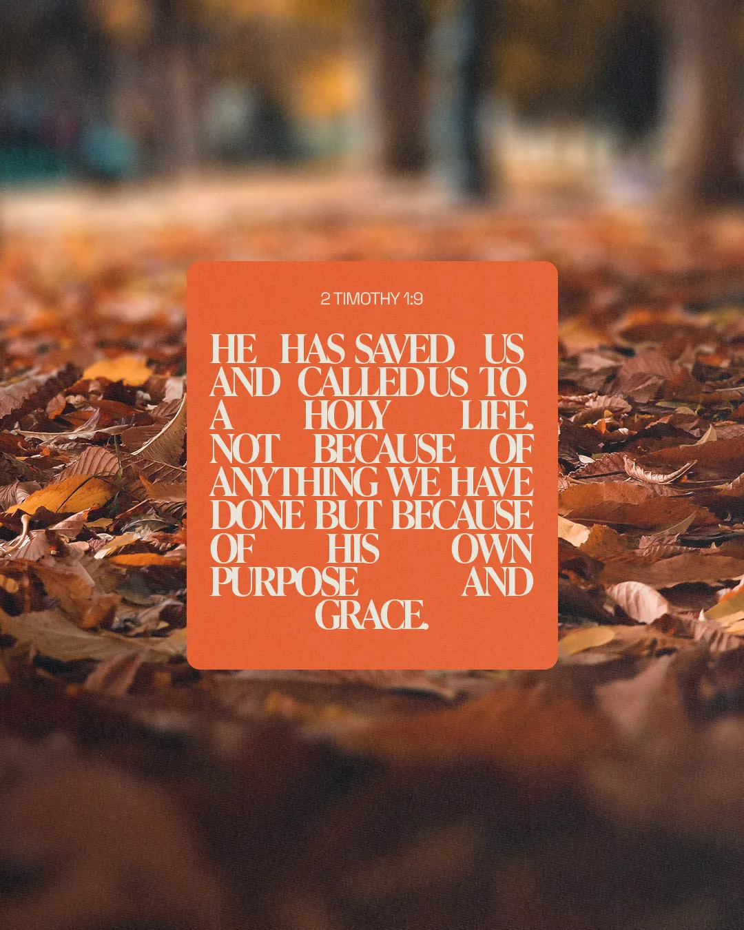 2 Timothy 1:9 quote emphasizes salvation and purpose, surrounded by autumn leaves, symbolizing renewal and grace.